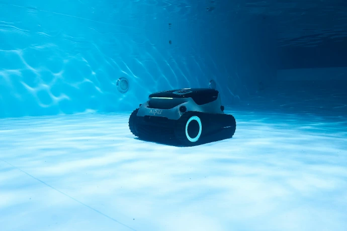 A robot vacuum is cleaning a pool underwater.